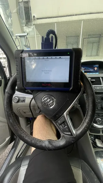 Autel key programming tablet mounted on the steering wheel of a Buick