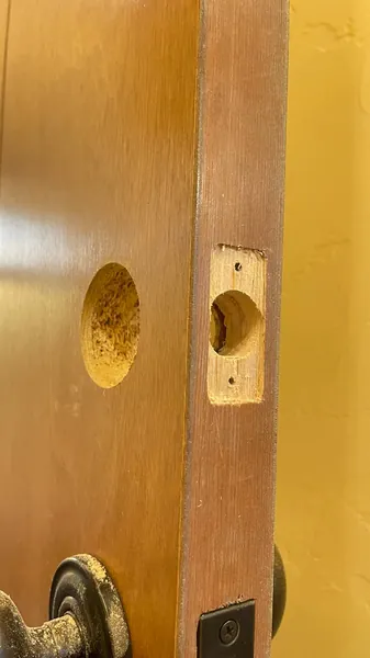 Door edge with the old lock removed and bore holes showing