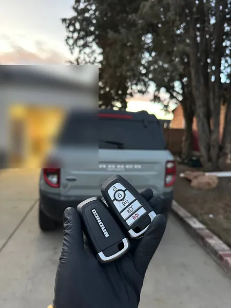 Two Ford Bronco smart keys held behind a Bronco Sport