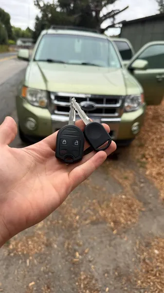 Ford remote and transponder key held in front of a green Ford SUV