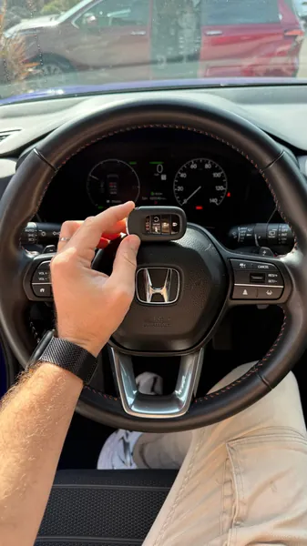 Honda smart key held at the steering wheel