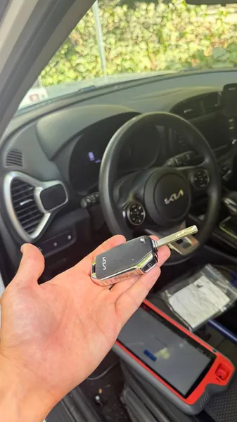 Kia flip key with a key programmer on the seat