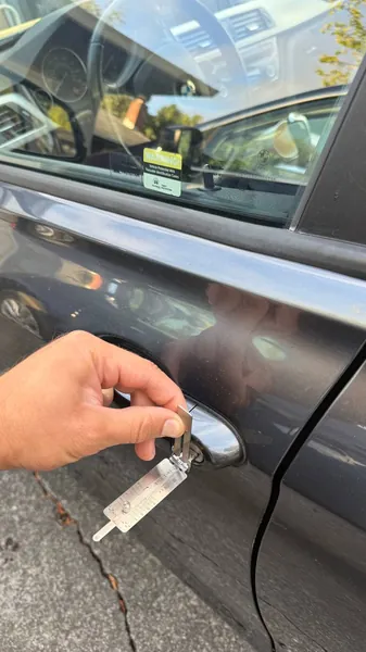Lishi pick tool in the driver door lock of a dark sedan