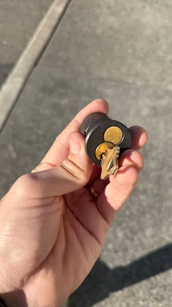 Lock cylinder with its keys, held in hand