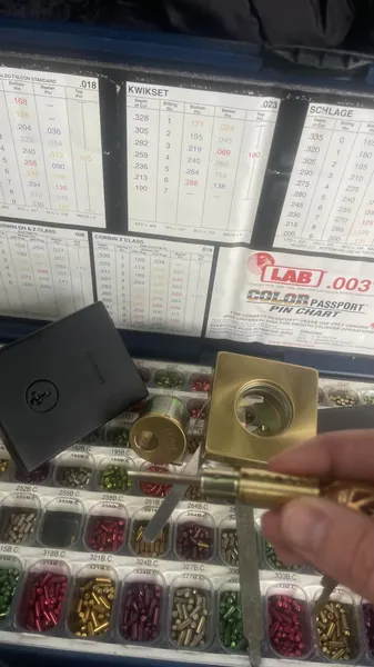 Brass lock cylinder being rekeyed over a LAB pin kit with Kwikset and Schlage pin charts