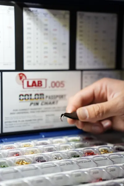Pin tweezers over a rekeying kit with a color pin chart