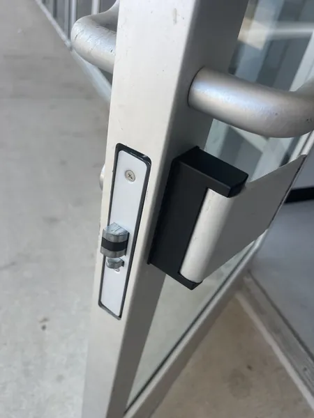 Aluminum storefront door with a mortise lock cylinder and a paddle handle