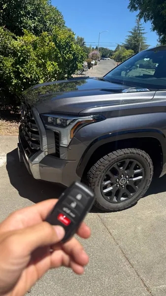 Toyota smart key held in front of a gray Toyota pickup