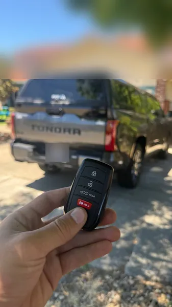 Toyota smart key held behind a gray Toyota Tundra