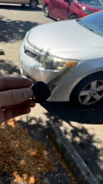 Transponder key held next to a silver sedan